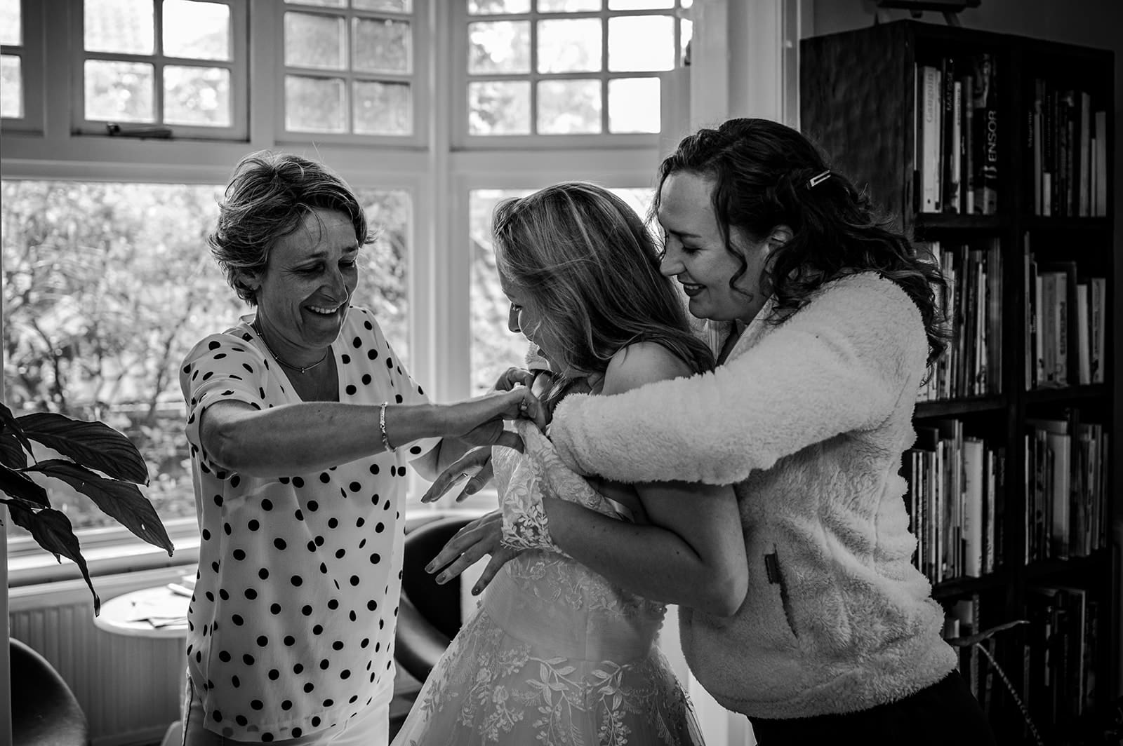 Familie helpt de bruid met haar jurk tijdens de voorbereidingen op de trouwdag in Schalkhaar