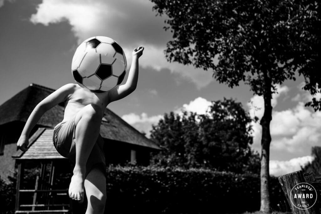 Kind speelt met een bal in de tuin, vastgelegd in een speels en ongepland moment